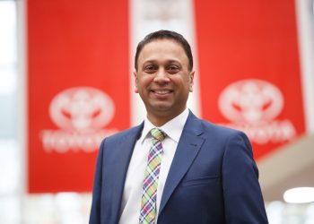 Neeraj Lala, Toyota New Zealand CEO standing in front of Toyota flags