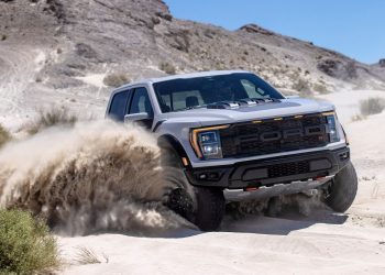 Ford F-150 Raptor R driving through sand in desert front three quarters