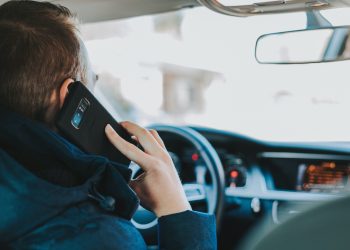 Man using phone while driving car