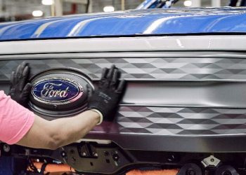 Ford badge being applied to F150 Lightning by worker