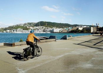 Man riding bike by water