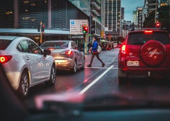 Woman crossing road with traffic waiting