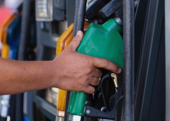 Person grabbing petrol pump nozzle