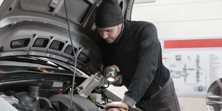Mechanic inspecting car engine