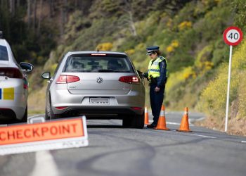 Police woman stopping driver at checkpoint