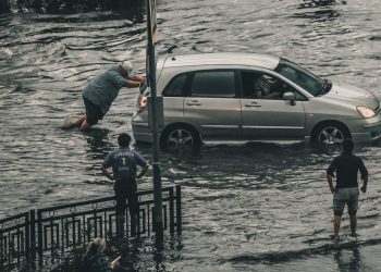 Man pushing car in flood