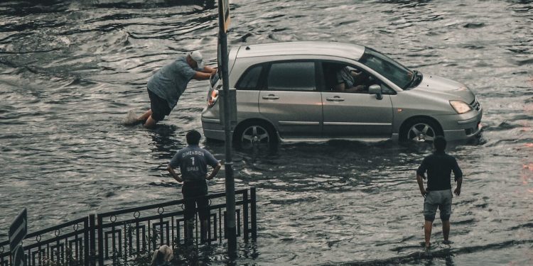 Man pushing car in flood