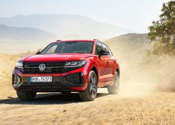 Third-generation Volkswagen Touareg driving on dirt past tree