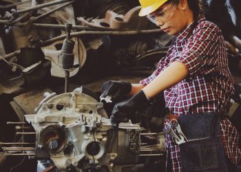 Woman mechanic working on engine