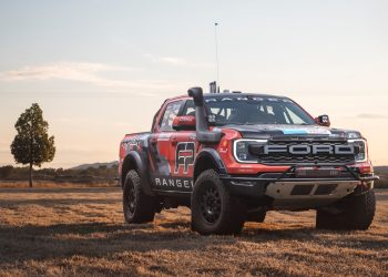 Ford Ranger Raptor race truck parked in field by tree