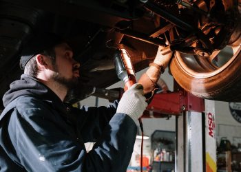 Mechanic inspecting car wheel