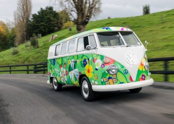 Fully electric Volkswagen Kombi driving past field