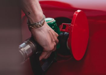 Person filling red car up with petrol