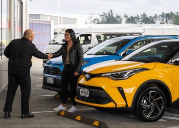 Man handing keys to woman next to Toyota CH-R