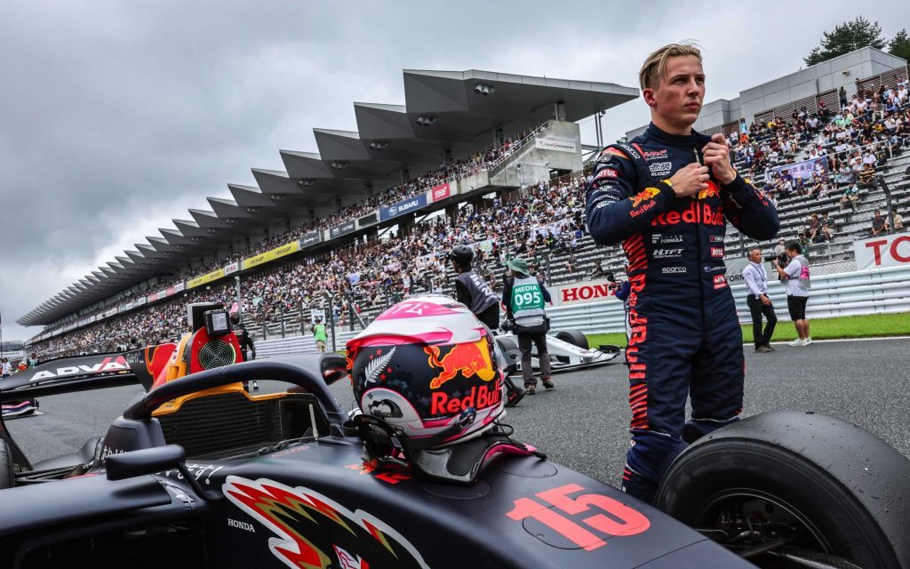 Liam Lawson standing with Super Formula car at Fuji Speeday 2023