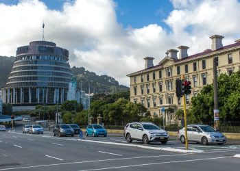 Cars driving on road past beehive in Wellington