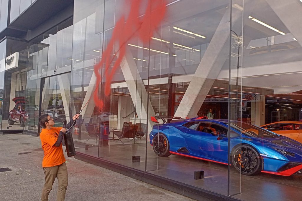 Climate activist vandalising Auckland luxury car dealership