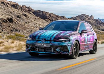 2024 Volkswagen Golf GTI driving on road in desert