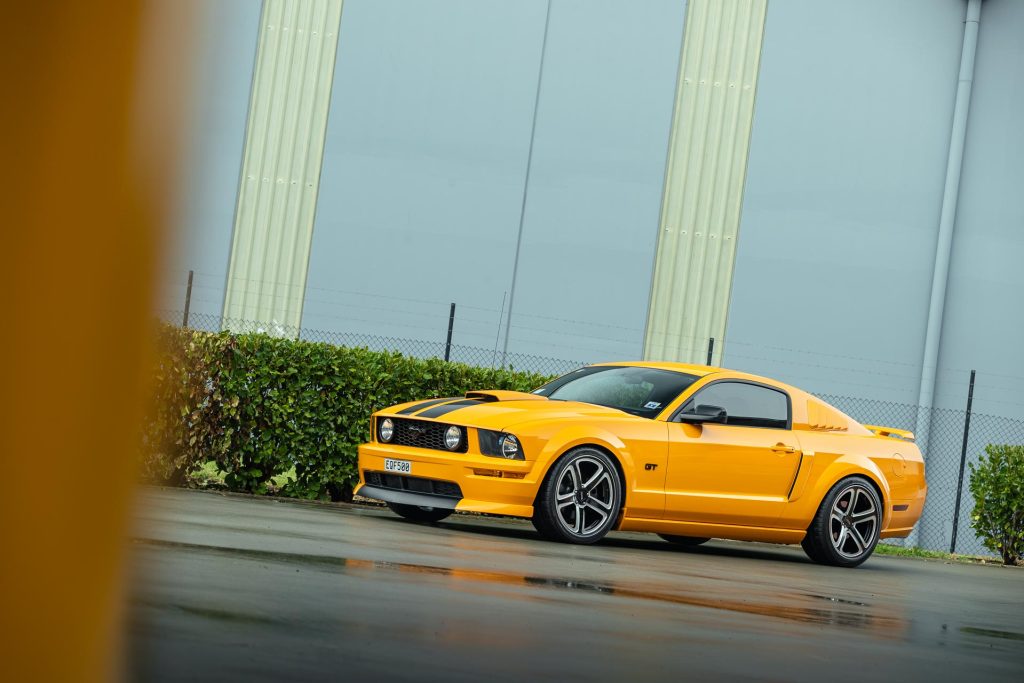 2007 Ford Mustang GT in yellow, parked in the rain