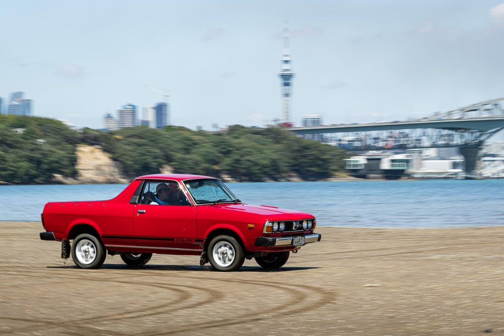 Subaru Brumby front panning view, in front of Auckland harbour bridge