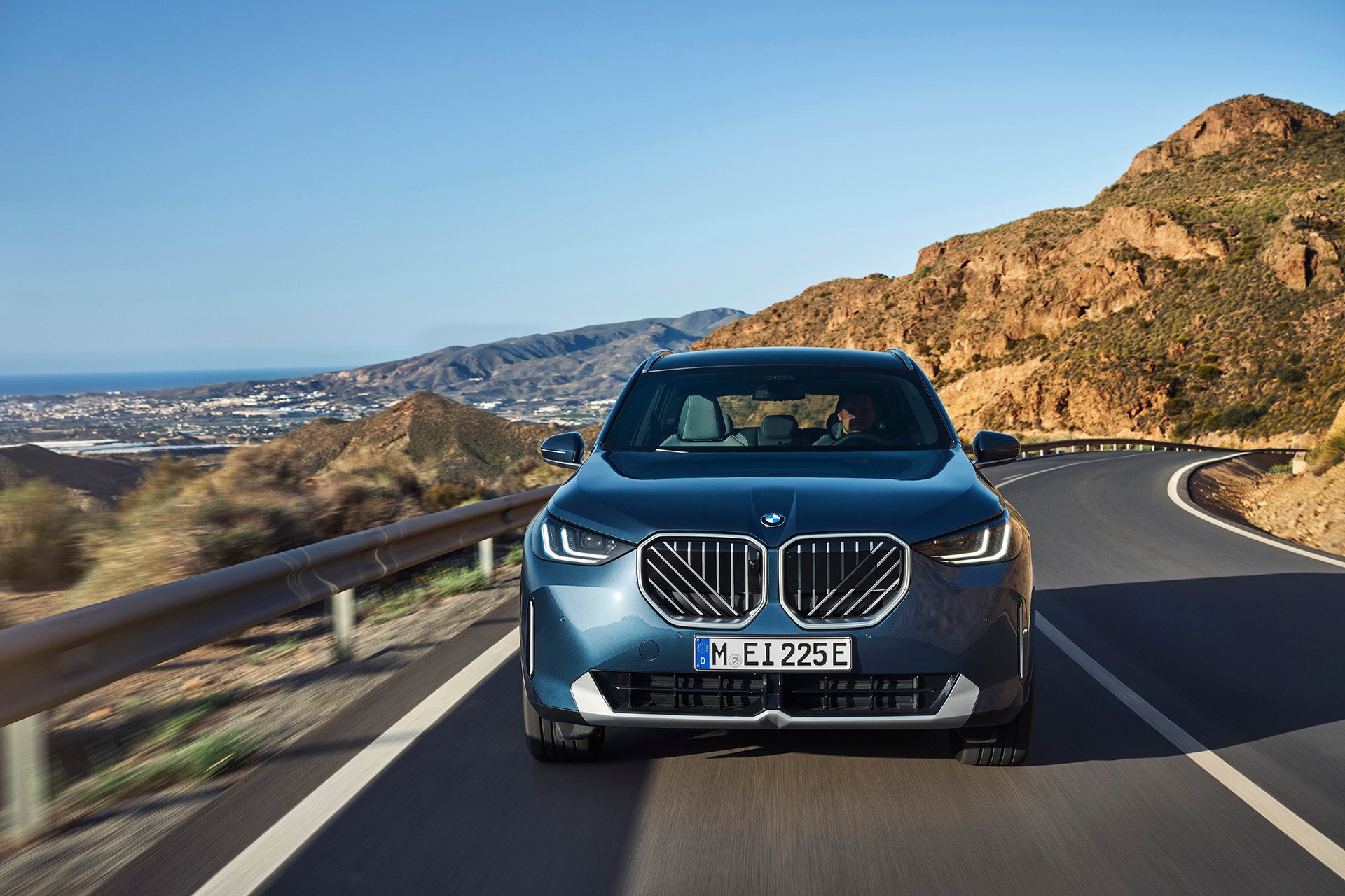 BMW X3 new grille, above city.