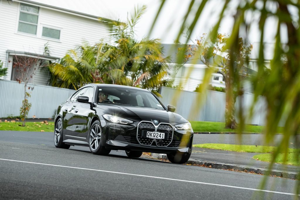 BMW i4 eDrive35 in black, taking a corner in a suburban neighbourhood