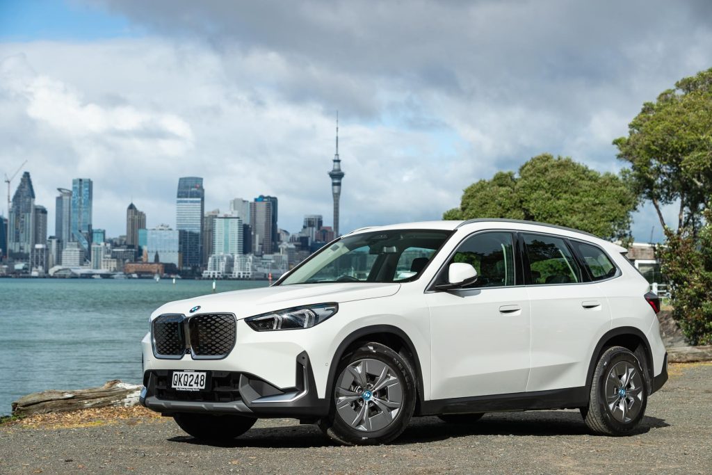 BMW iX1 eDrive20 in white, parked with the Skytower in the background