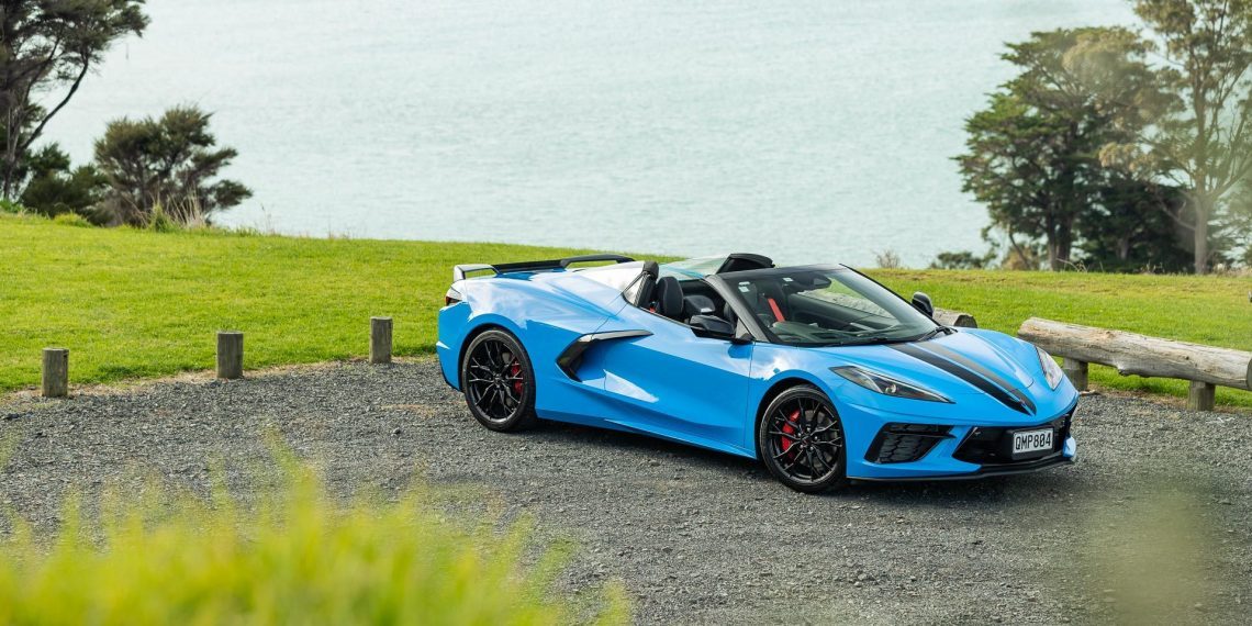 Chevrolet Corvette Stingray 3LT convertible in blue, parked with an ocean view behind
