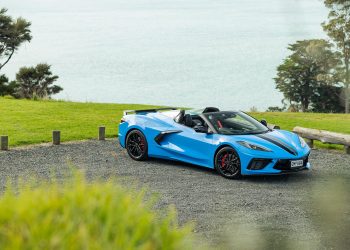 Chevrolet Corvette Stingray 3LT convertible in blue, parked with an ocean view behind