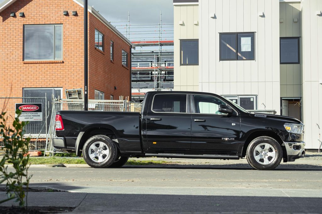 Ram 1500 Big Horn side profile, parked next to a construction site