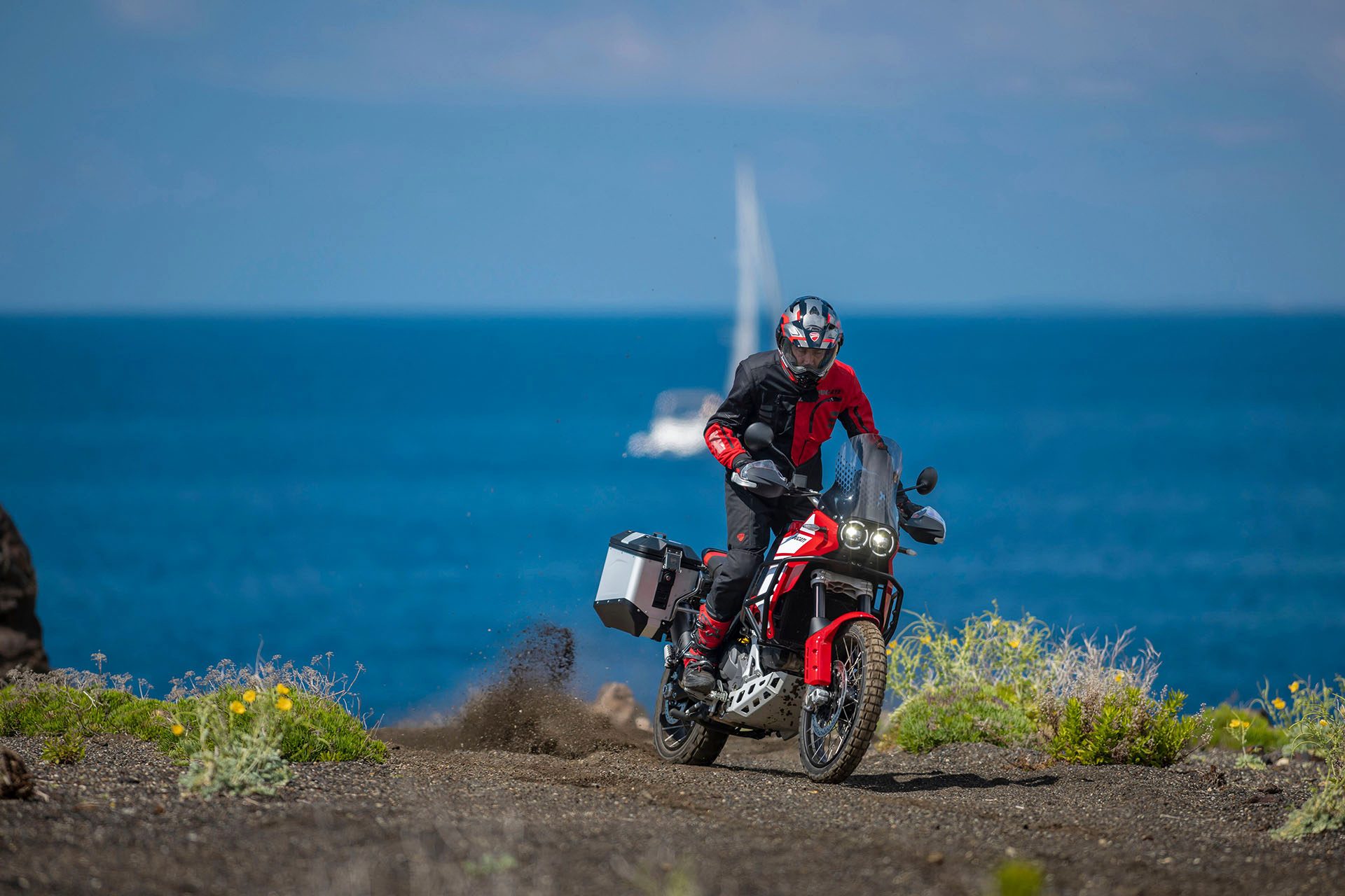 Ducati DesertX Discovery skidding over a brow.