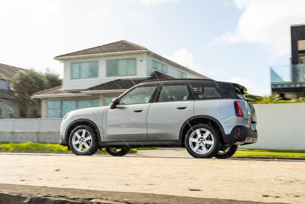 Mini Countryman Core Classic panning shot next to a beach, taken in the pouring rain