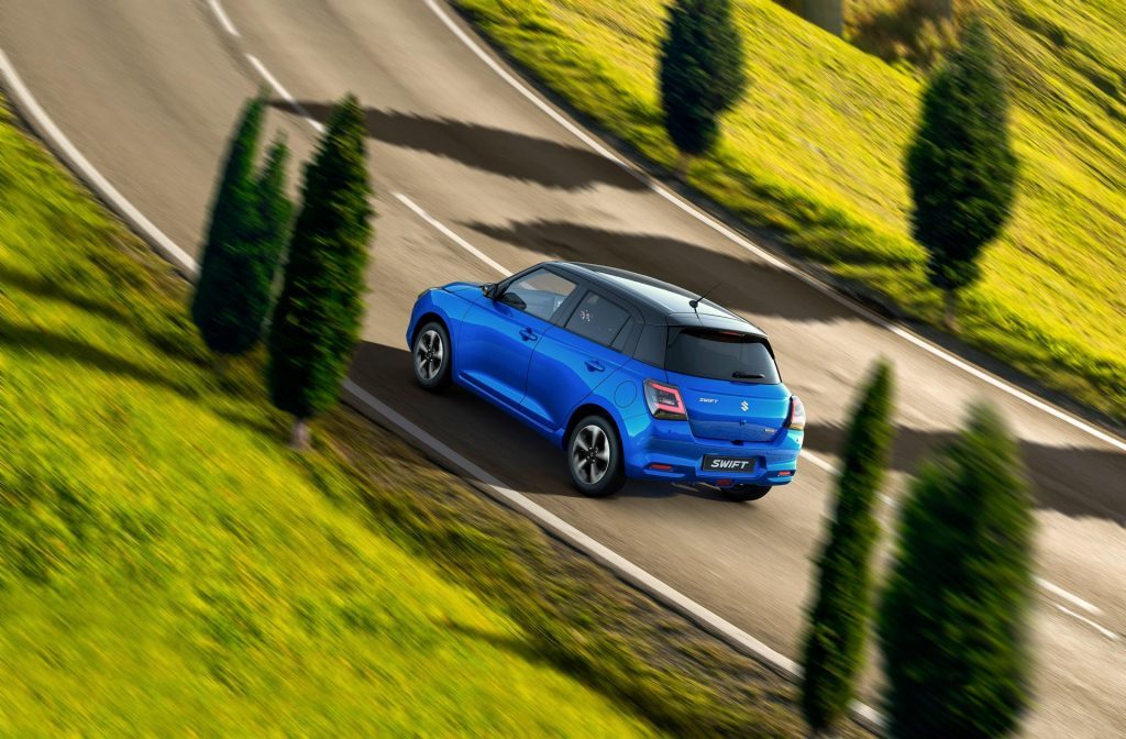 Suzuki Swift RS CVT in blue, driving through a country backroad