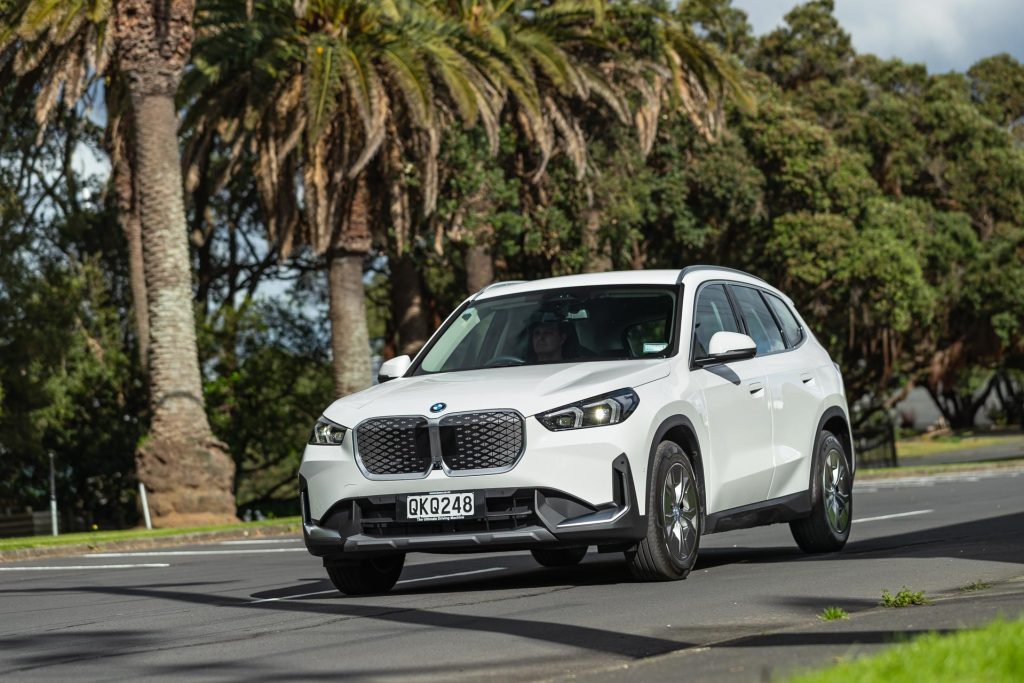 Driving shot of a white 2024 BMW iX1 eDrive20