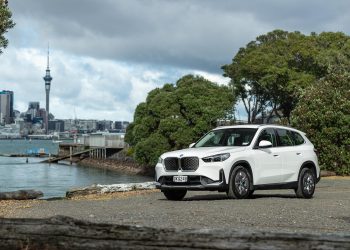 BMW iX1 in white, parked with Auckland's city skyline behind