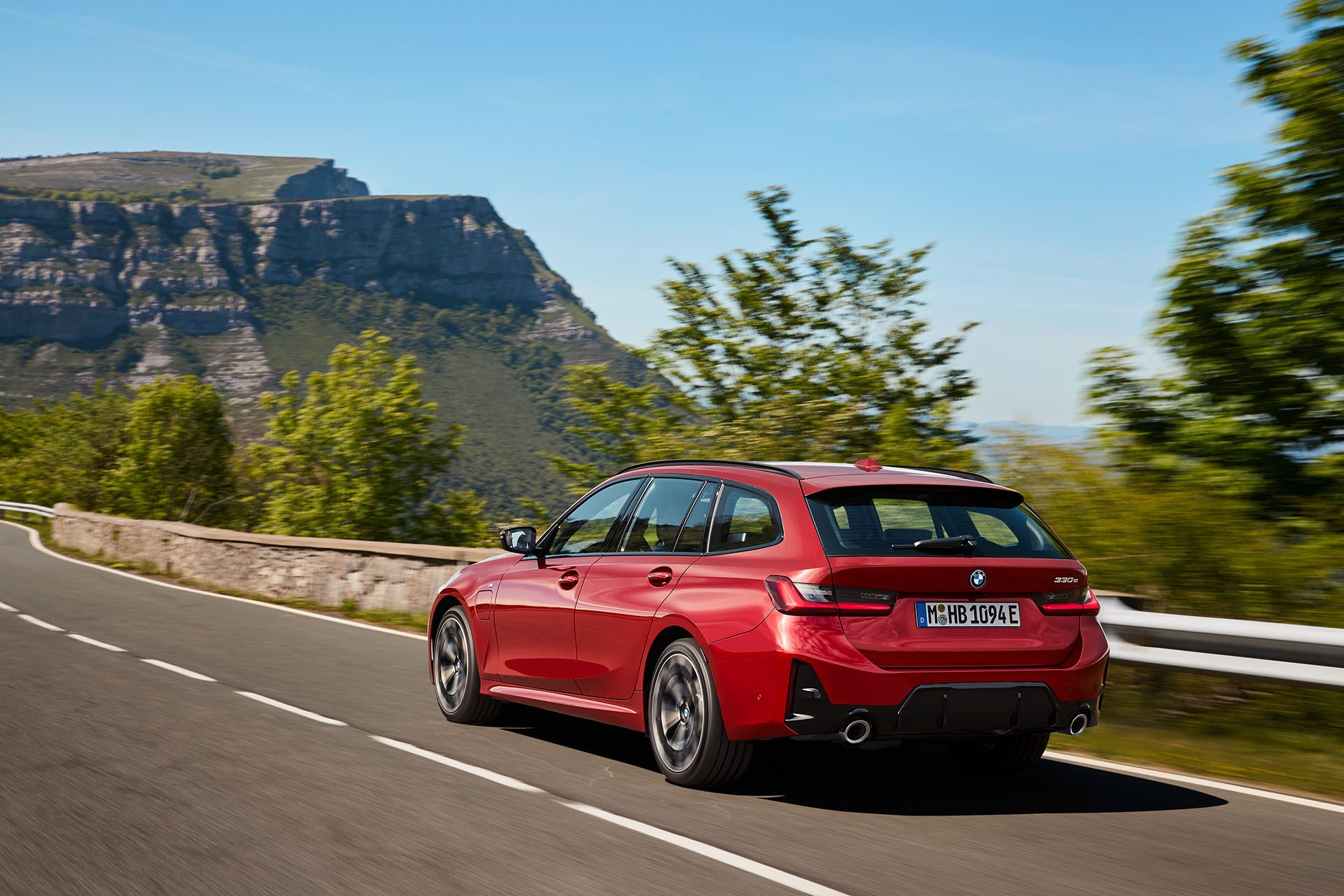 BMW 3 Series Touring in red on road.