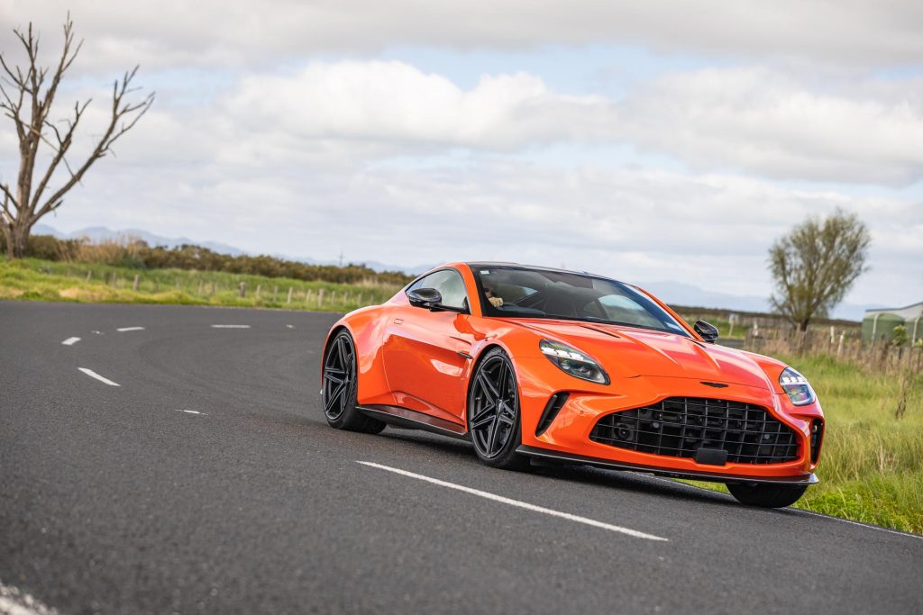 2024 Aston Martin Vantage in orange, taking a corner at pace