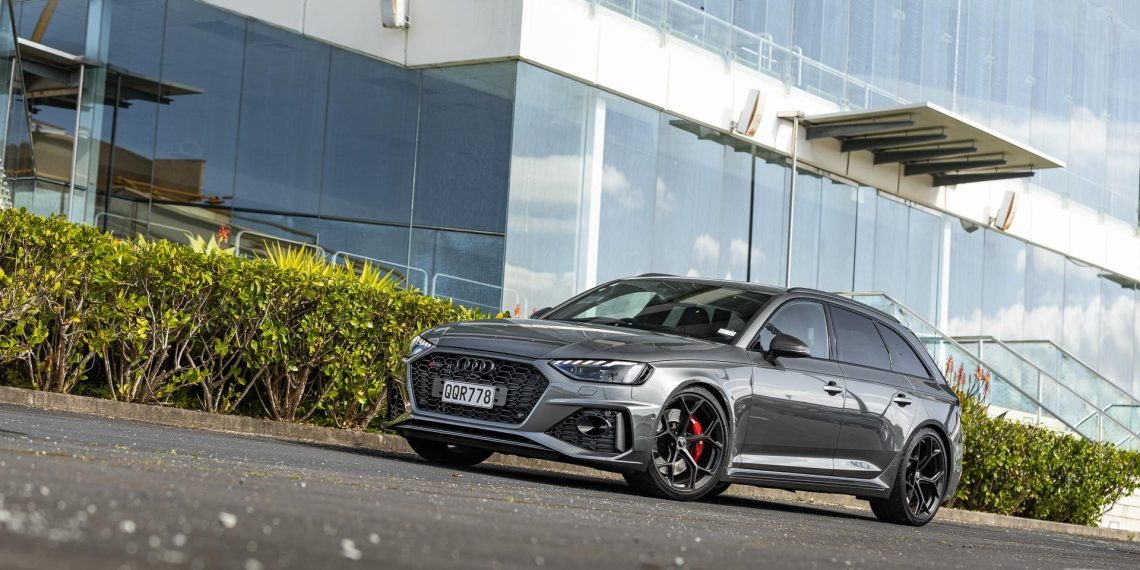 Audi RS4 Competition front quarter shot, parked in front of glass building