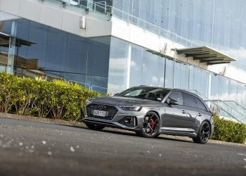 Audi RS4 Competition front quarter shot, parked in front of glass building