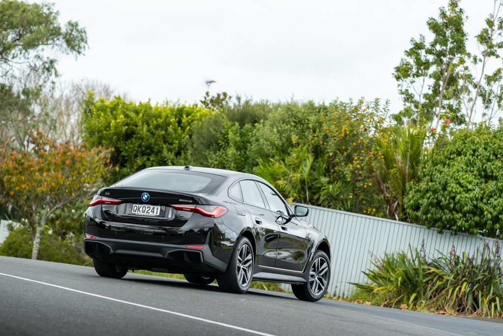 2024 BMW i4 eDrive35 rear view, shown taking a corner at pace