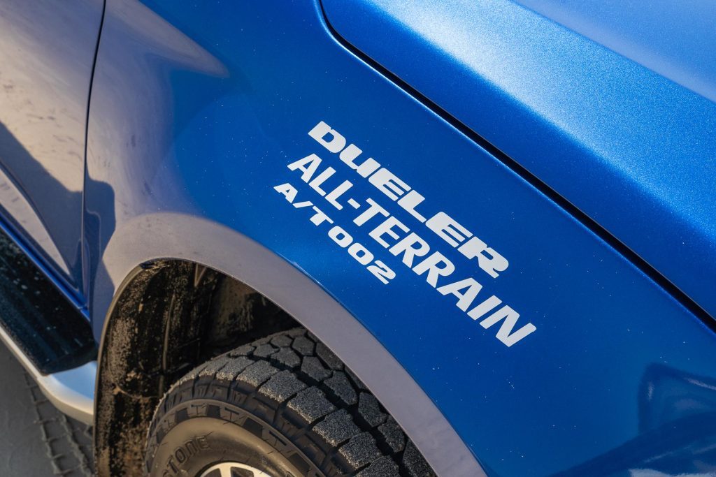 Bridgestone Dueler A/T 002 signage on a blue SUV