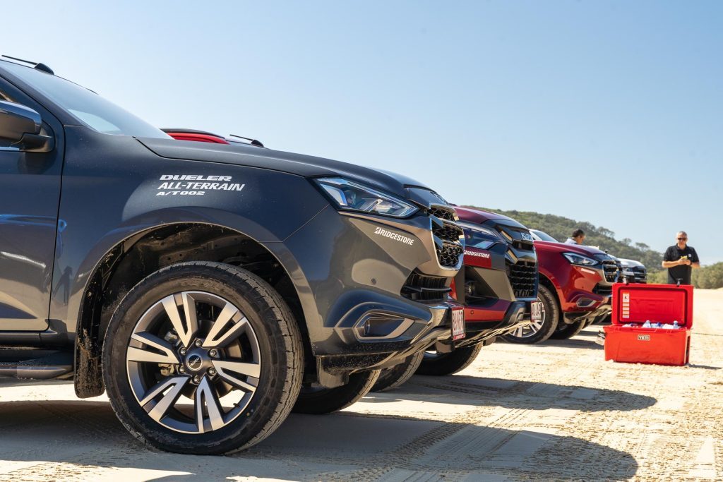 Isuzu MU-X SUVs with Bridgestone Dueler A/T 002s equipped. Ice cooler in the background