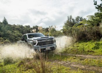 Chevrolet Silverado 2500 HD LTZ splashing through a muddy puddle on a backroad