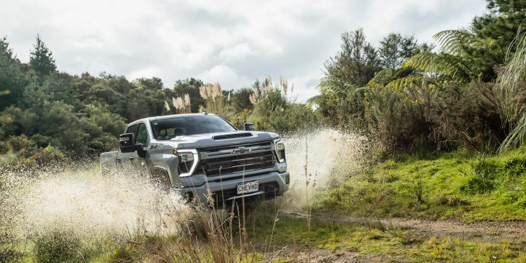 Chevrolet Silverado 2500 HD LTZ splashing through a muddy puddle on a backroad