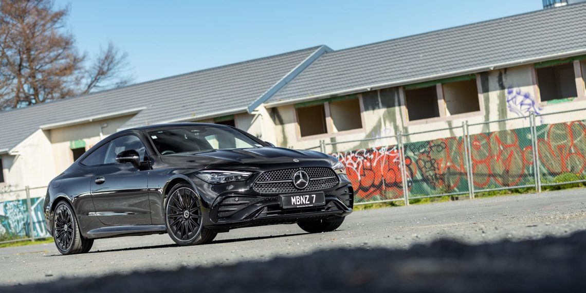 Mercedes-Benz CLE 300 in black, parked next to a row of abandoned houses