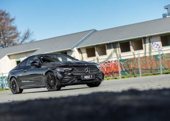 Mercedes-Benz CLE 300 in black, parked next to a row of abandoned houses