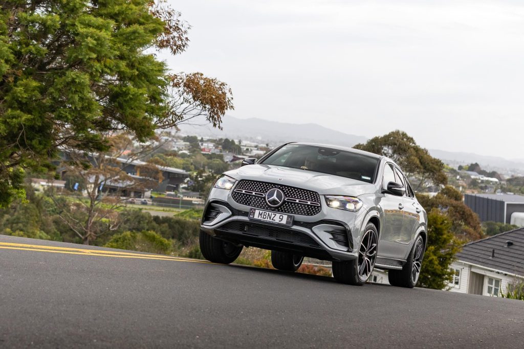 Mercedes-Benz GLE 450 4matic Coupe SUV taking a corner over a hill