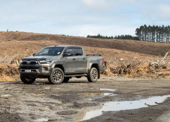 Toyota Hilux SR5 Cruiser Hybrid front quarter, parked in the mud next to a forestry field