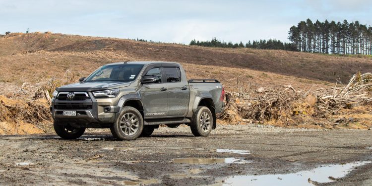 Toyota Hilux SR5 Cruiser Hybrid front quarter, parked in the mud next to a forestry field