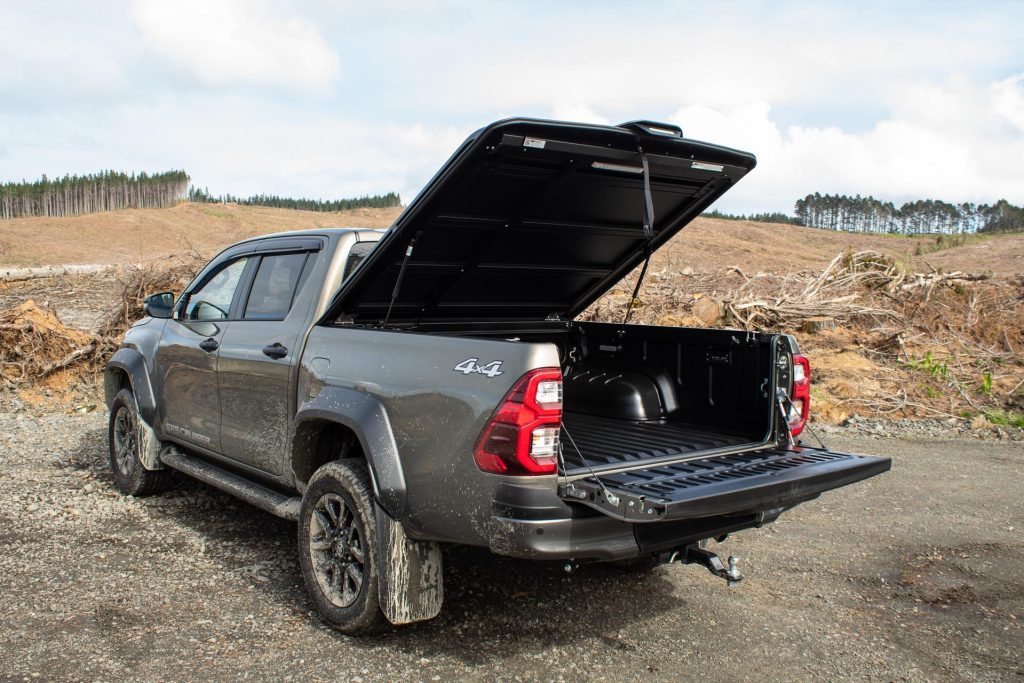 2024 Toyota Hilux SR5 Cruiser Hybrid with tray cover open, parked on gravel